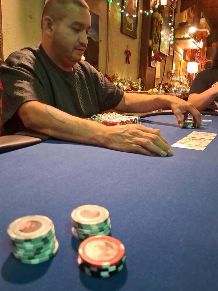 Dwan dealing cards at a poker table, chip rack in front of him